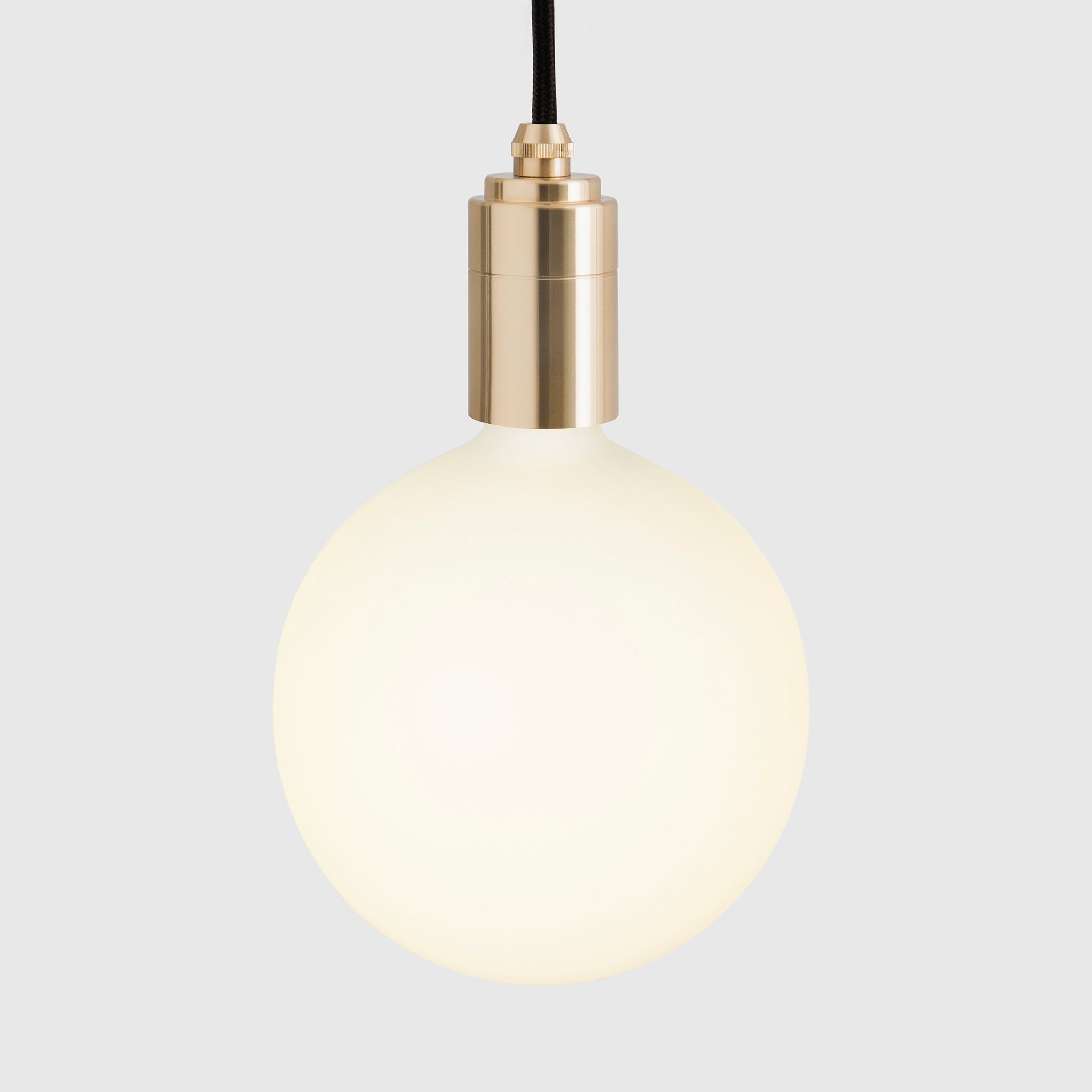 Tala Linear Triple Pendant in Brass, close-up of the Sphere IV bulb on grey background