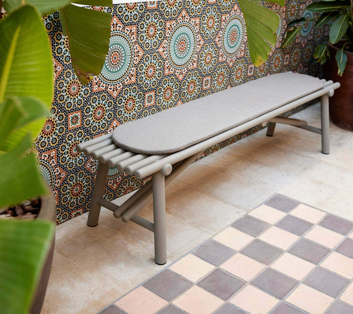 Cane-line Sticks Bench in Taupe, styled in a garden setting, powder-coated aluminum sticks