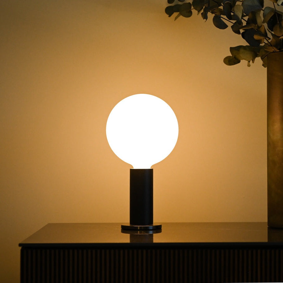 Tala Knuckle table lamp with Sphere IV bulb in Oak, styled in a holiday interior, view 1