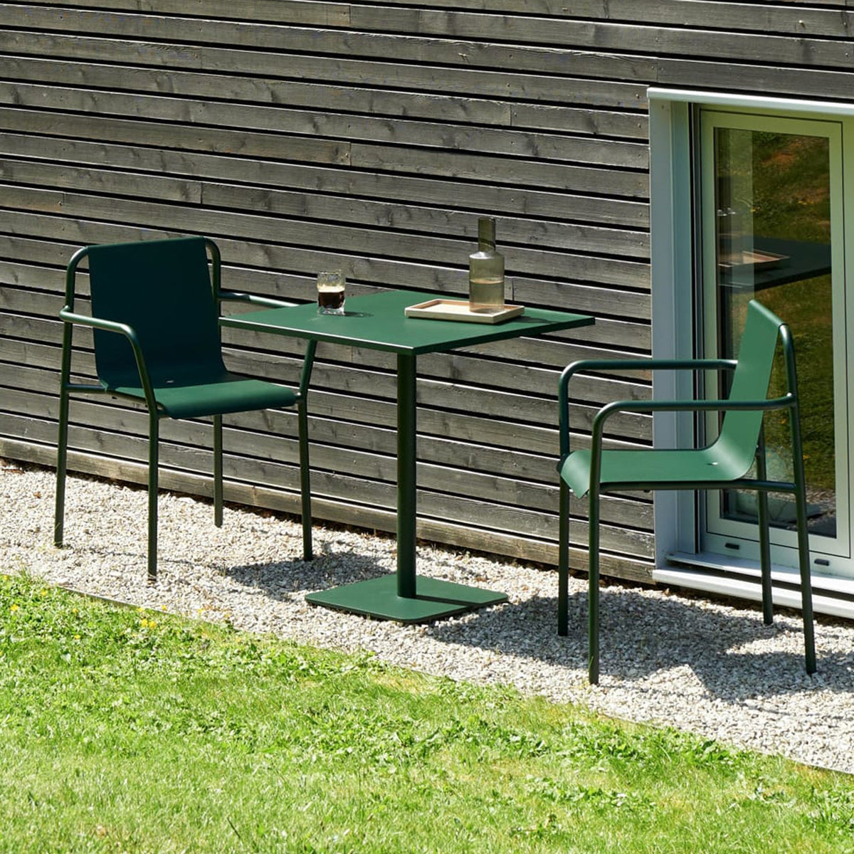 Tiptoe PANORAMA Outdoor Armchairs in Forest Green with a matching table on a lawn, powder-coated steel