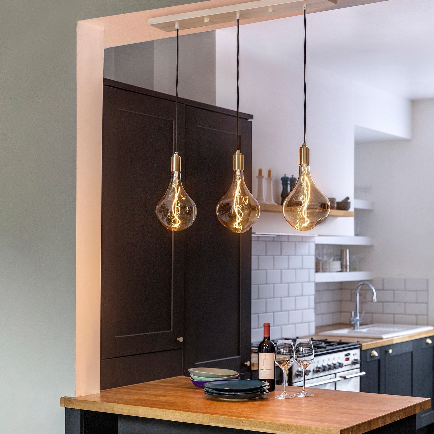 Tala Linear Triple Pendant in Brass with Voronoi II bulbs, styled in a kitchen