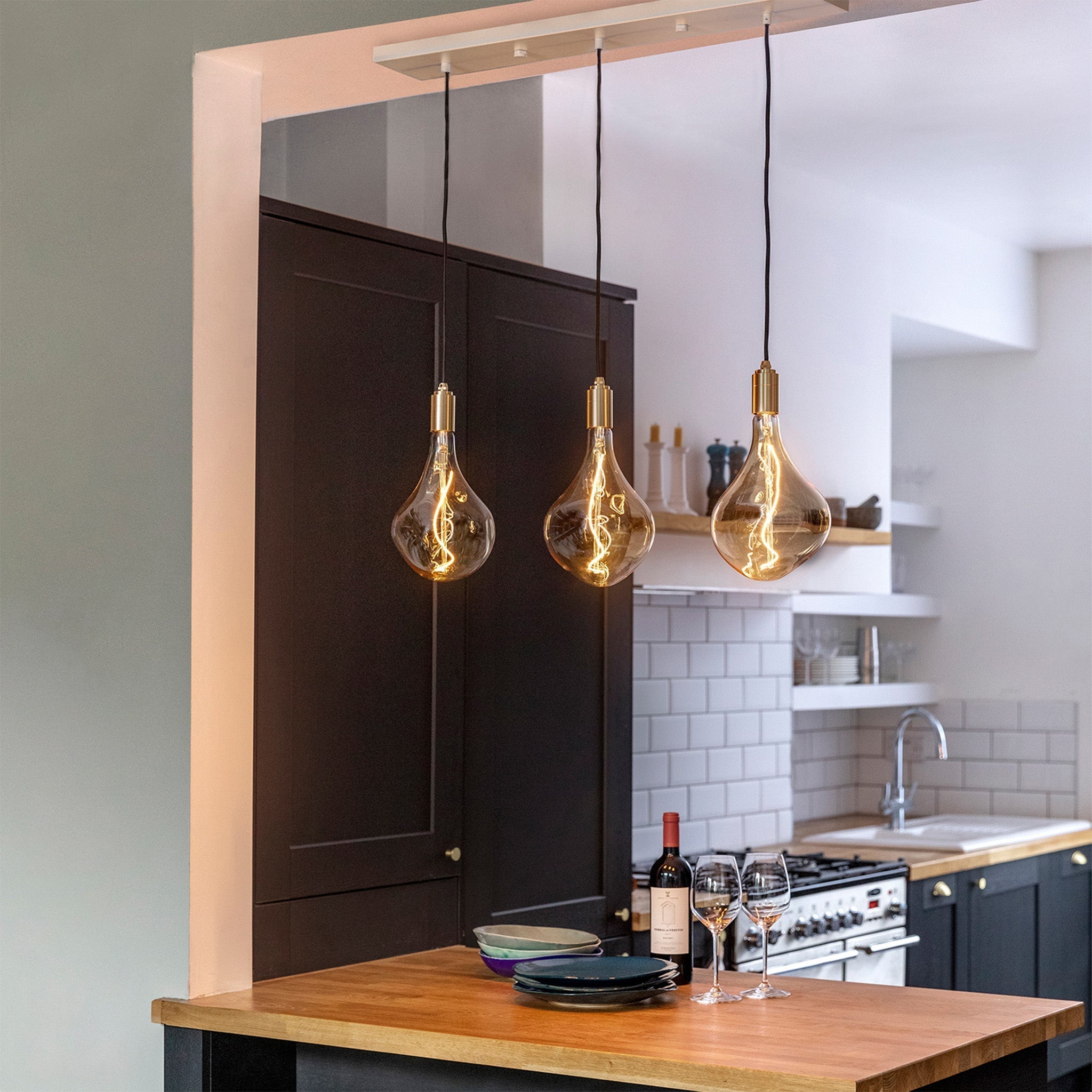 Tala Linear Triple Pendant in Brass shown with Voronoi II bulbs, kitchen lifestyle photo