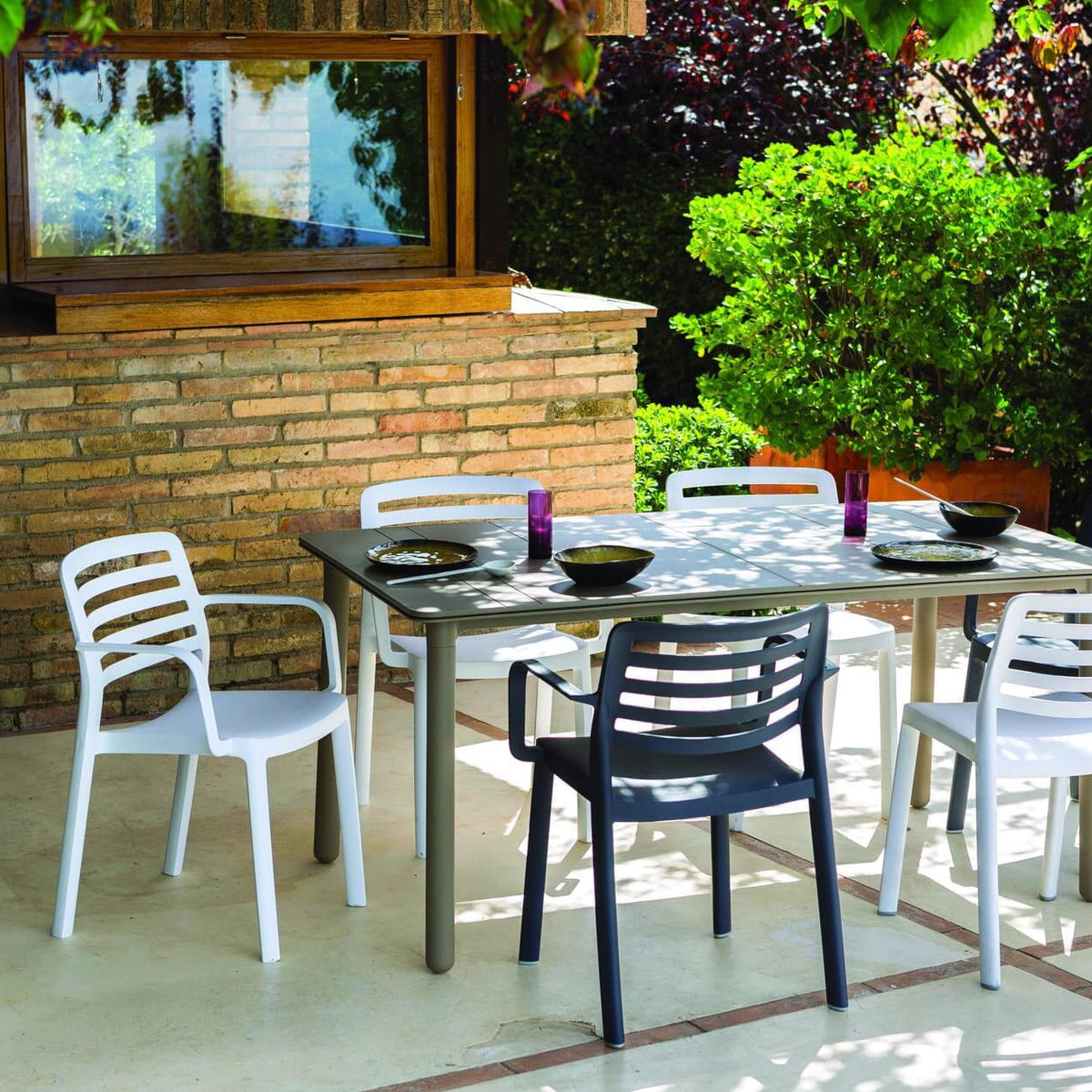 Garbar Wind Armchairs in White and Dark Grey around an outdoor dining table