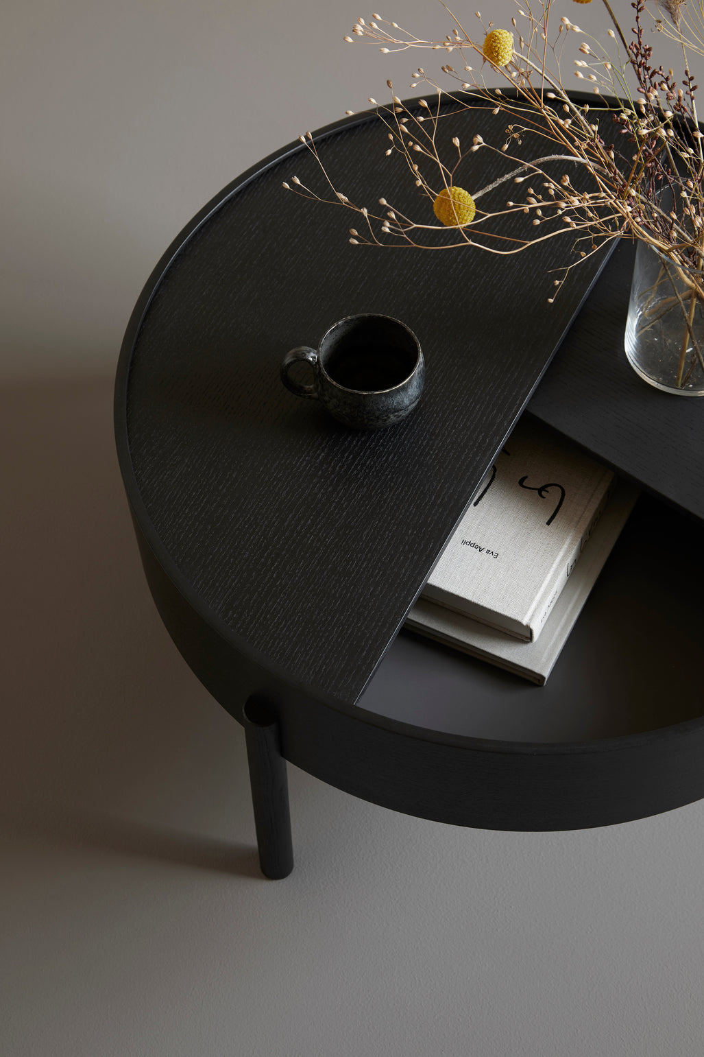 Detail of WOUD Arc Coffee Table with the black ash top turned open over the storage well