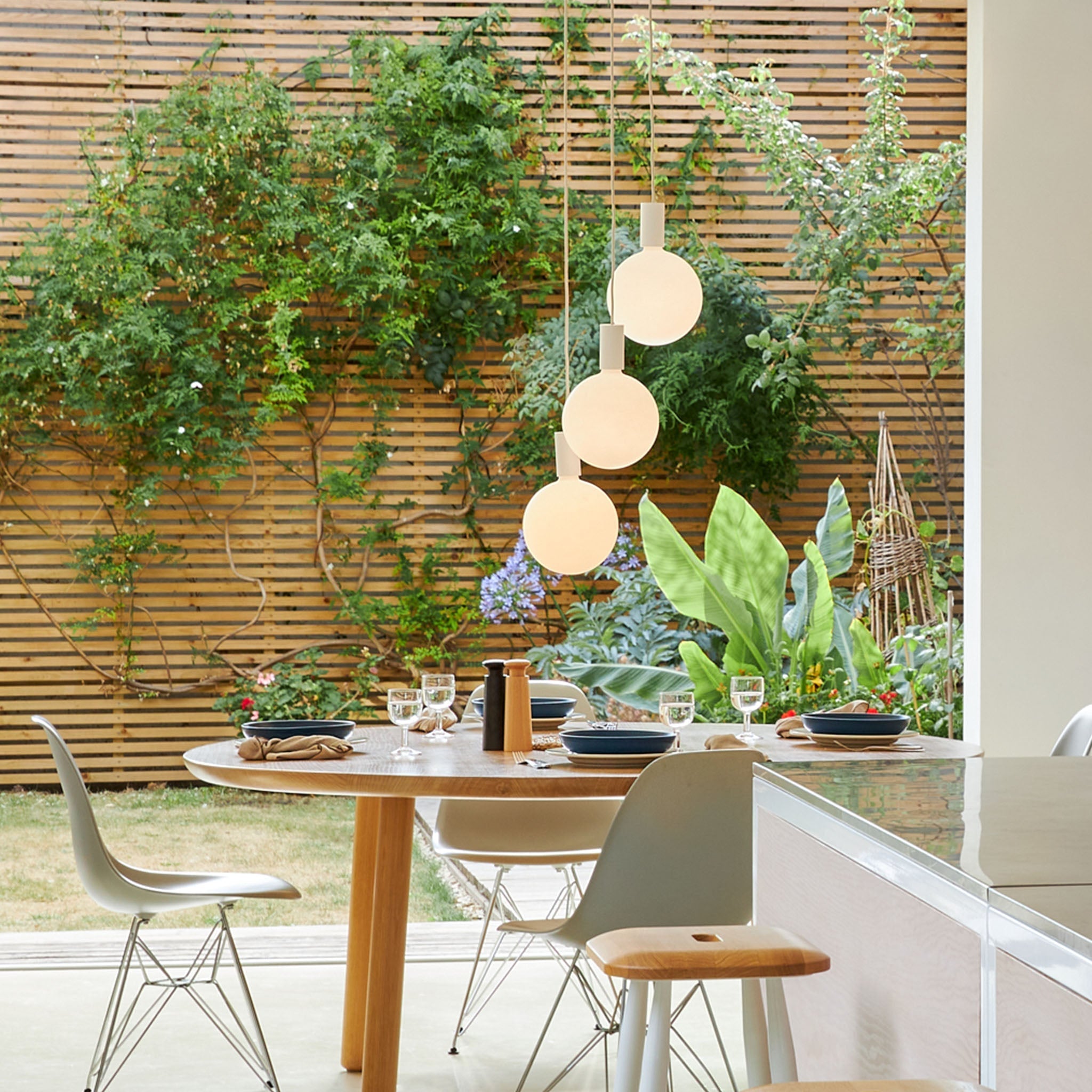 Alumina Triple Pendant with Sphere V bulbs by Tala, side profile of the lit fixture