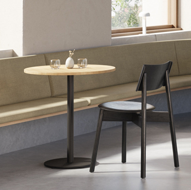 Tiptoe MOKA Bistro Table, round in Graphite Black, styled beside a banquette, solid oak and steel