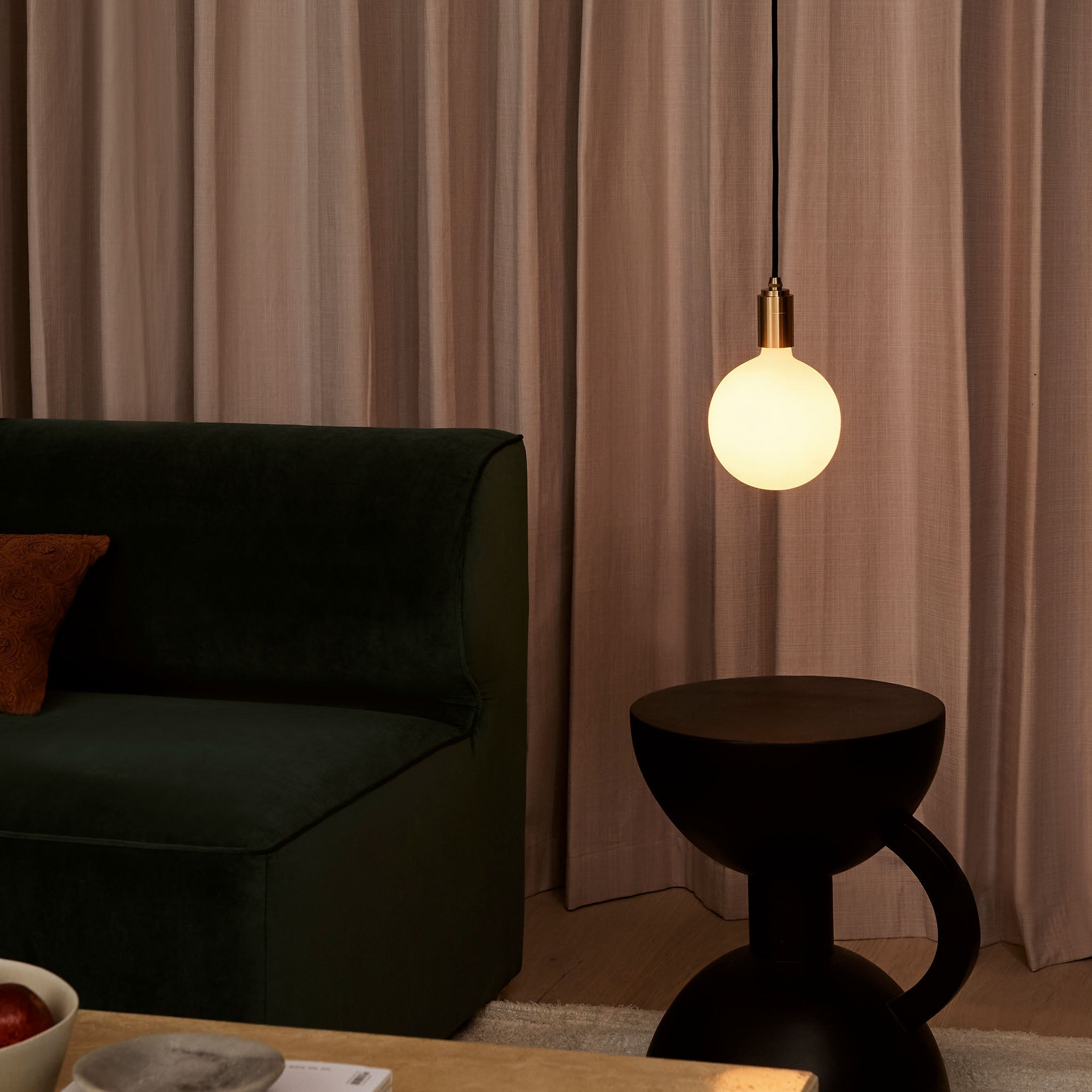 Tala Sphere IV Plug-In Pendant in Brass hanging in a living room