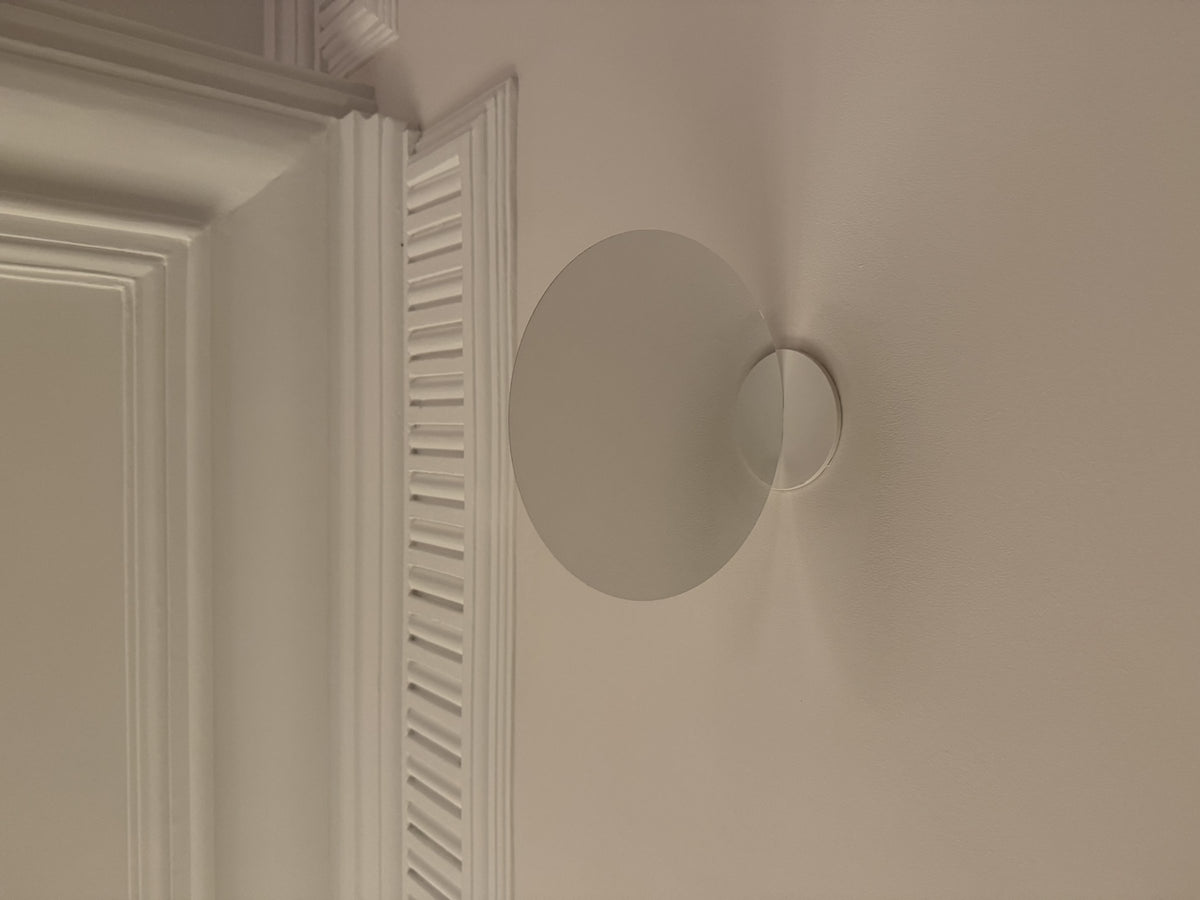 Luceplan Millimetro Wall Lamp disc beside a door casing