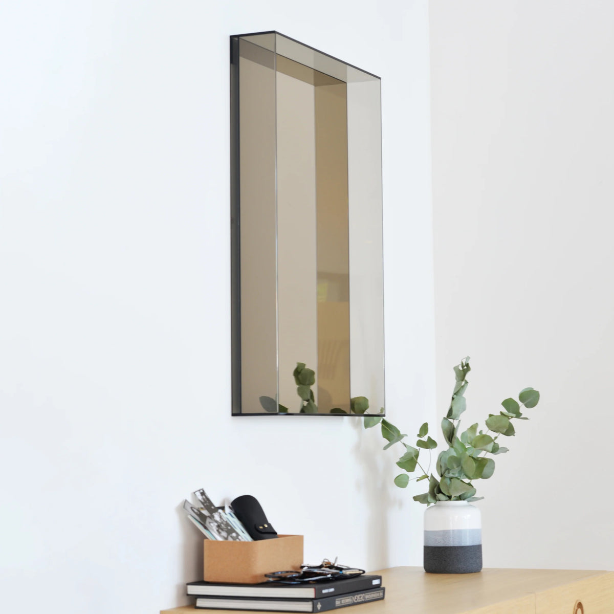 Case Lucent mirror in Bronze Glass hung above a desk, side view