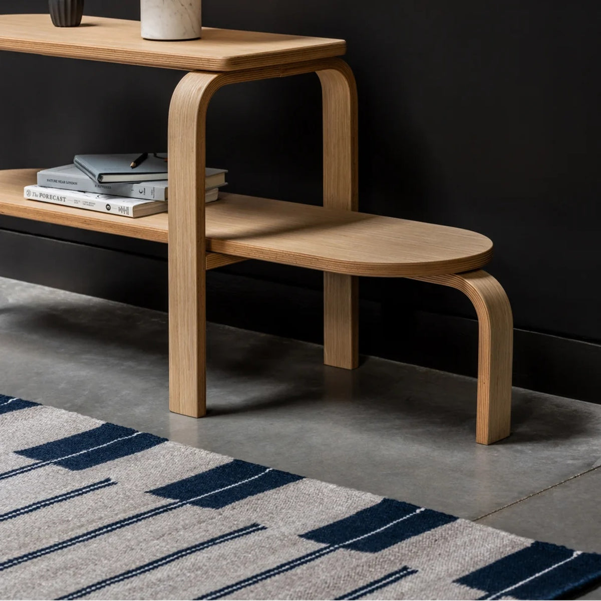 Detail of the Case Oar rug in navy and off-white on a concrete floor
