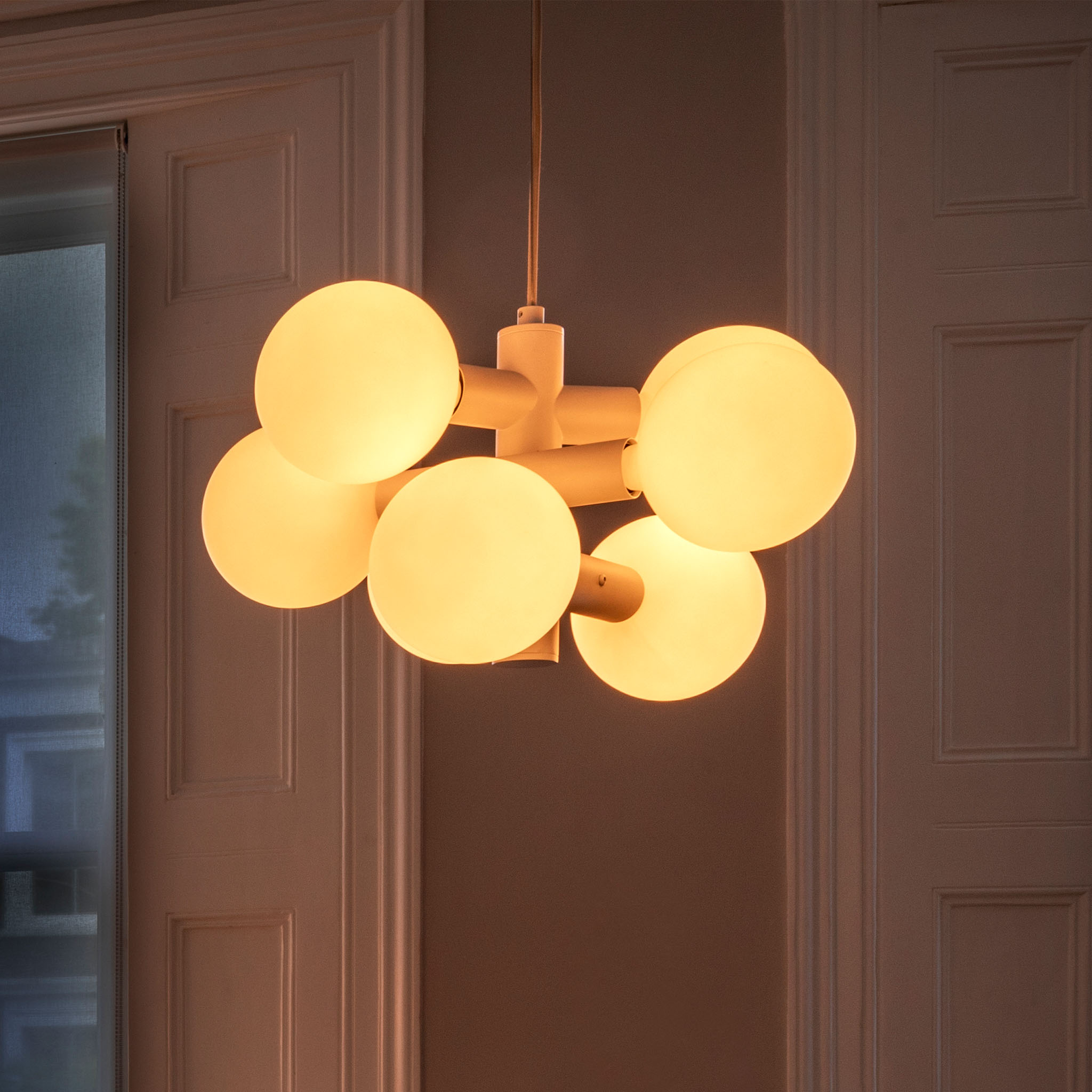 Detail of a porcelain globe and bulb on the Echo Chandelier