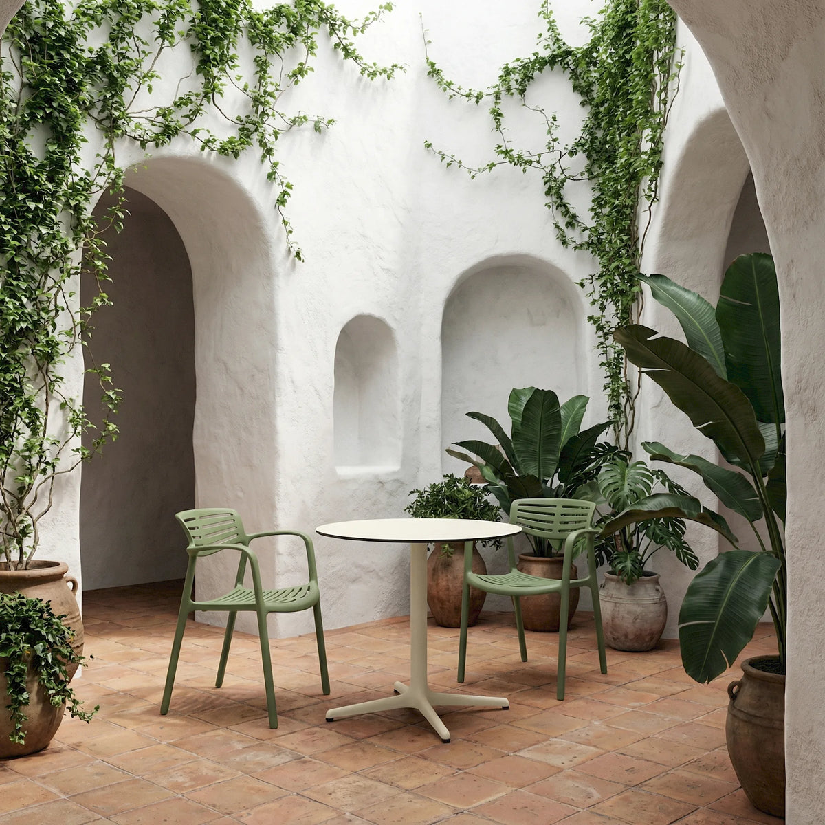 Resol Toledo round table in Ivory with Toledo Aire chairs, styled in a courtyard, painted aluminum and HPL