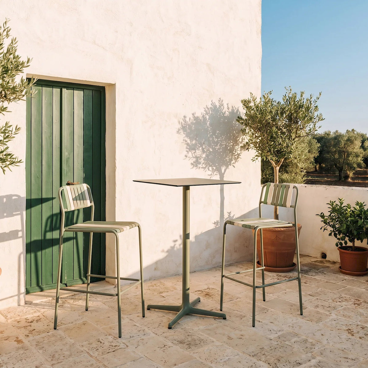 Resol Gelato bar stools with Salvia frames and Pistacchio slat mix at a high table by a green door