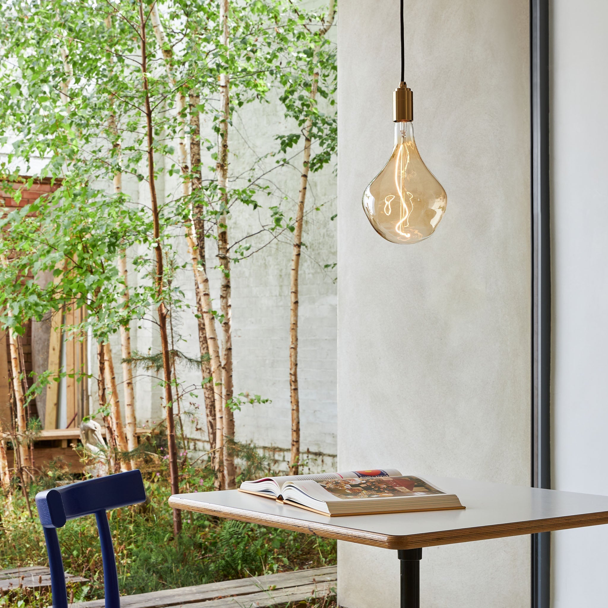 Brass Pendant with Voronoi II bulb in an outdoor setting