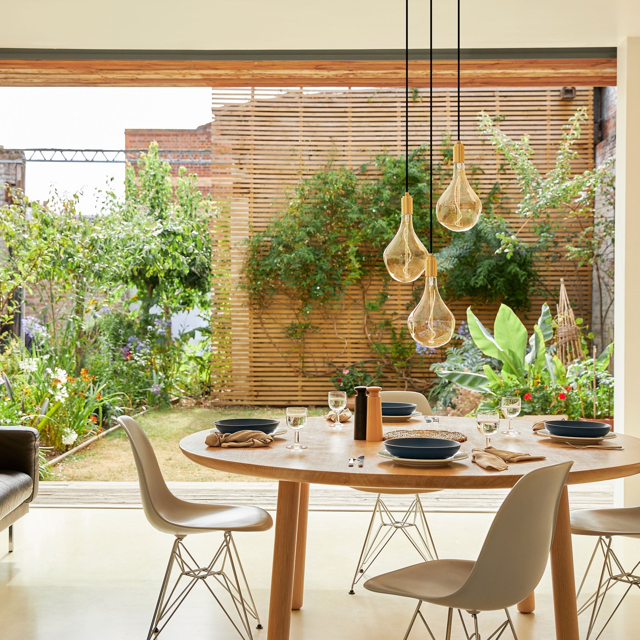 Tala Triple Pendant in Walnut with Voronoi II bulbs — indoor/outdoor living lifestyle